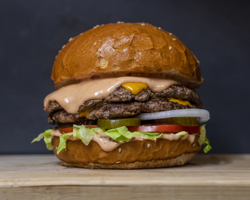 Double beef patty burger with melted cheese, pickles and sauce