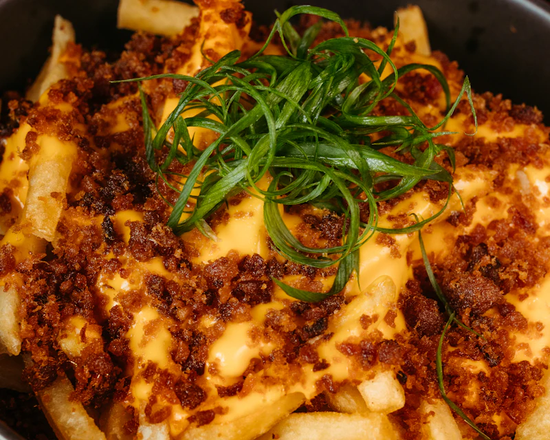 Fries loaded with cheese sauce, beef and spring onions