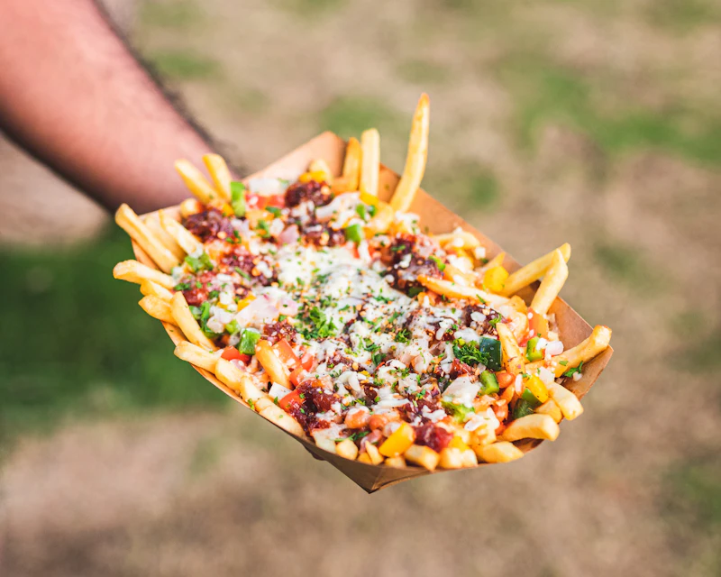 Tray of fries loaded with chicken, cheese and red sauce