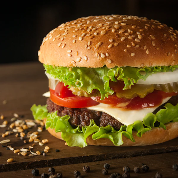 Burger with fresh lettuce and tomato beside a cup of fries
