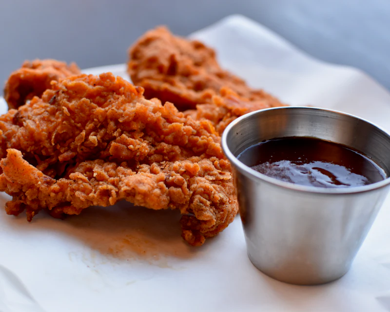 Crispy chicken tenders with a cup of dipping sauce